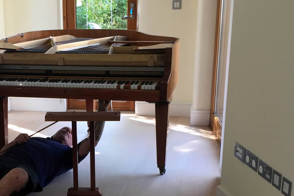 removals team dismantling piano