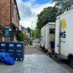 two Leicester Movers and Storers vans parked outside a house
