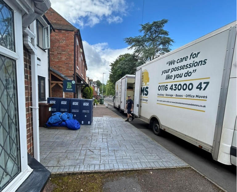 Leicester Movers & Storers vans parked outside a home